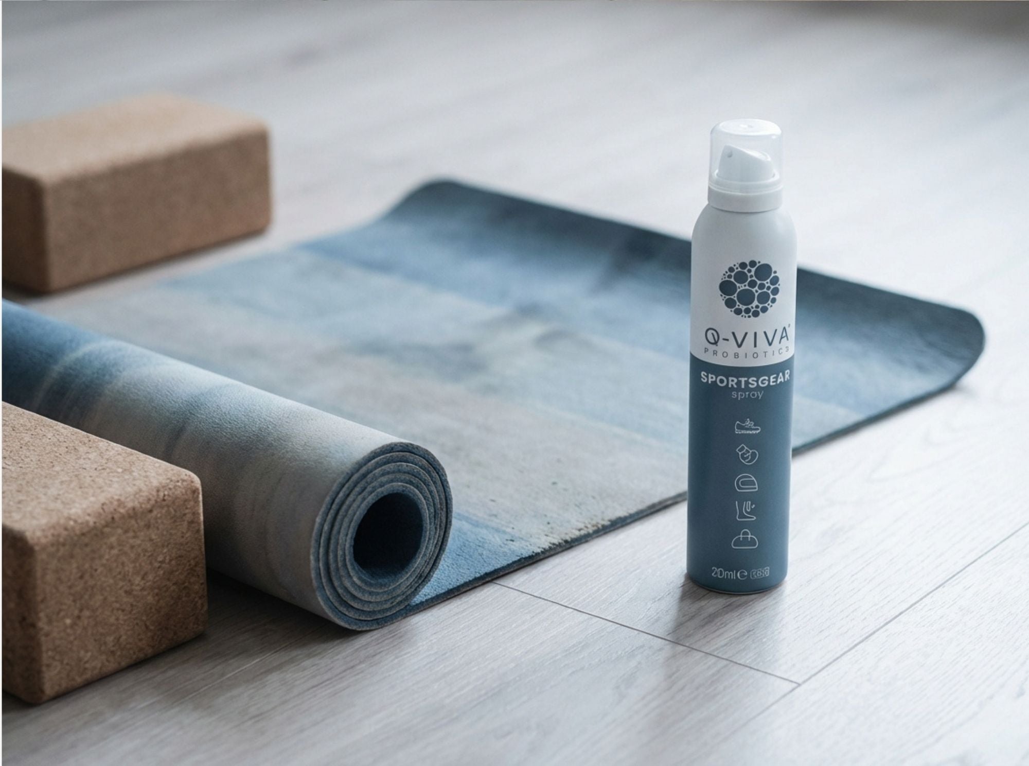 Q-Viva Sportsgear Spray naast een yogamat en blokken om matten fris te houden en geuropbouw te verminderen
