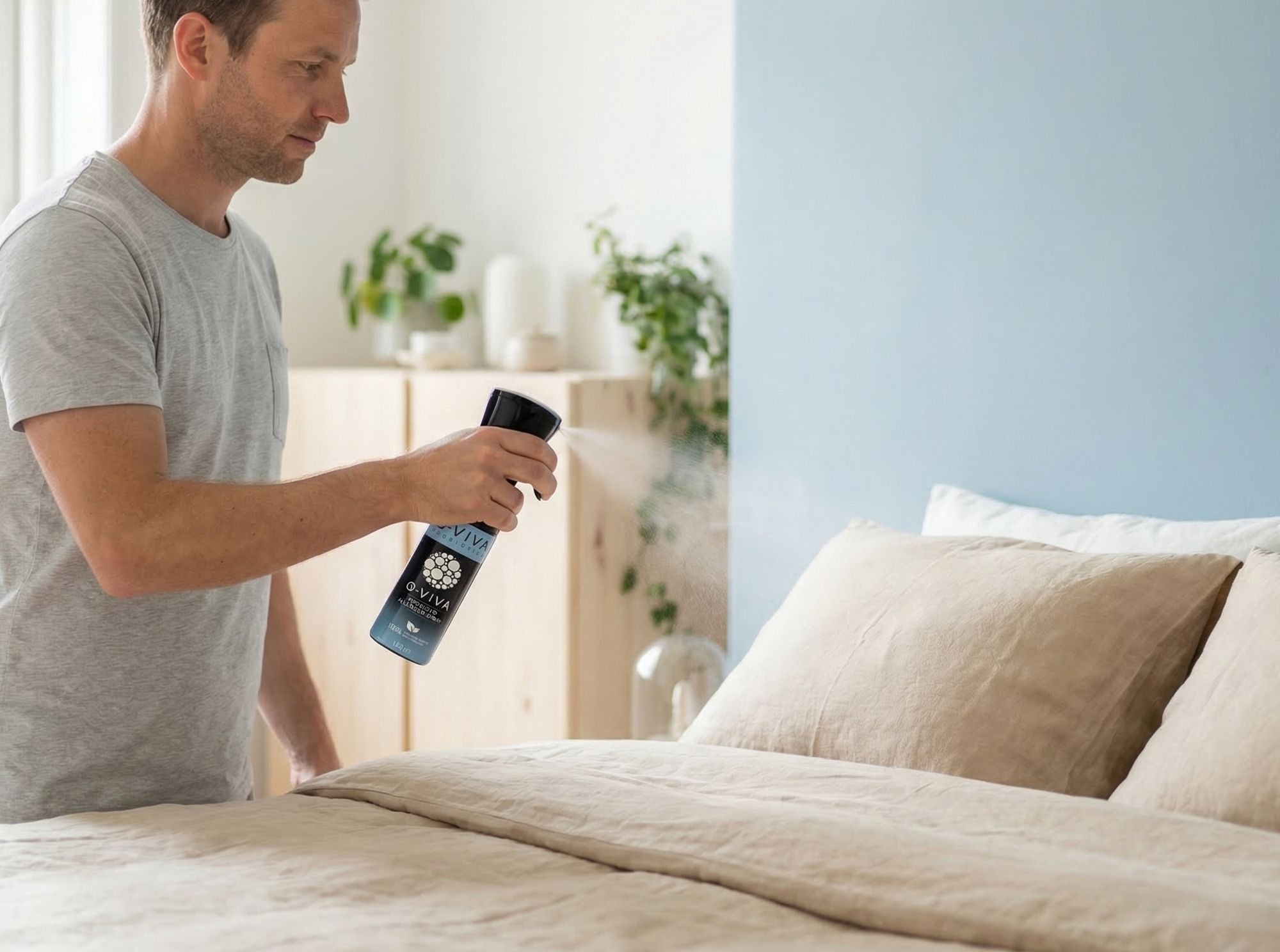 Persoon die Q-Viva Allergen Spray rechtstreeks op beddengoed sprayt en laat zien hoe het product op textiel wordt aangebracht