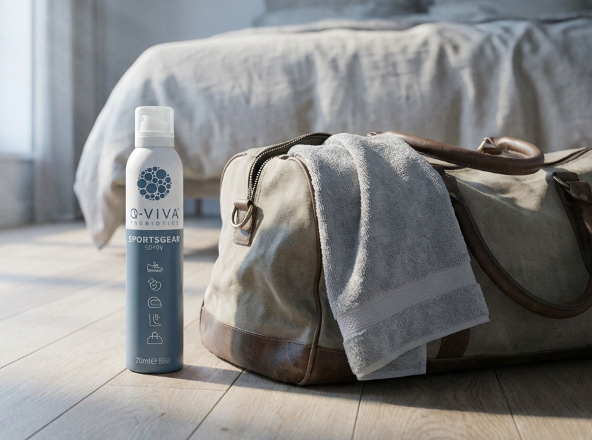 Q-Viva Sportsgear Spray naast een sporttas en handdoek om geuropbouw in sporttassen te verminderen