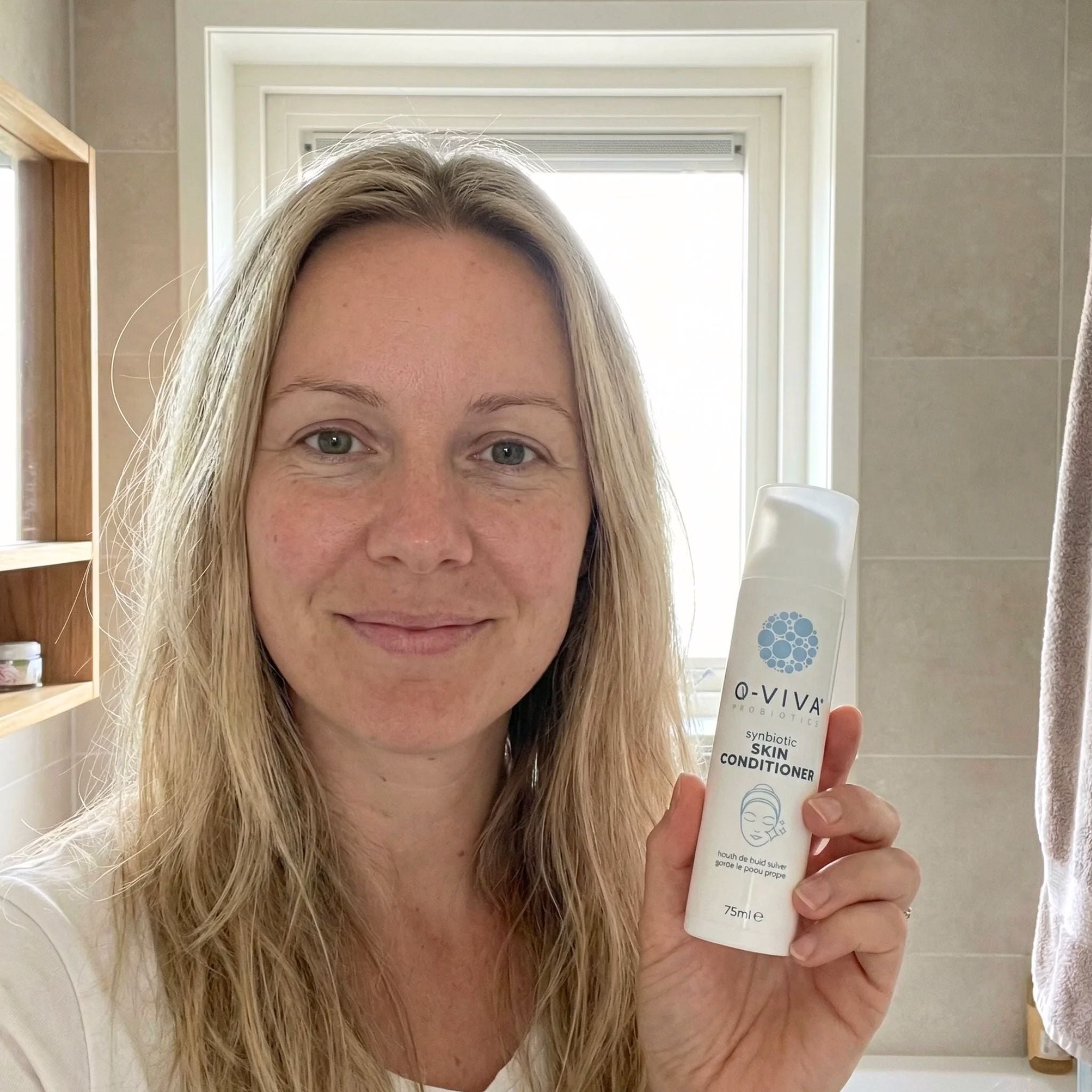 Vrouw die Q-Viva Skin Conditioner vasthoudt als echte klantervaring met verbeterd huidcomfort